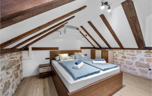 ein Schlafzimmer mit einem großen Bett mit blauer Bettwäsche in der Unterkunft Beautiful Home In Zlarin With Outdoor Swimming Pool, Wifi And 1 Bedrooms in Zlarin