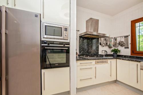 a kitchen with a stainless steel refrigerator and a microwave at Finca Sa Fuente in Felanitx