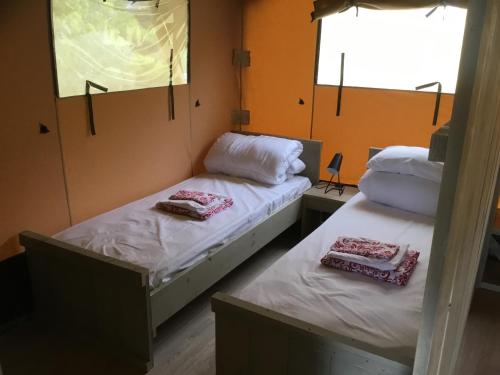 2 camas individuais num quarto com 2 janelas em Camping rural la Masia em Cocentaina