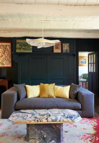 a living room with a couch and a table at La Longère de l'Amiral c'est au choix la Maison de l'Amiral jusqu'à 10 personnes ou le Carré de l'Amiral jusqu'à 4 personnes in Moëlan-sur-Mer