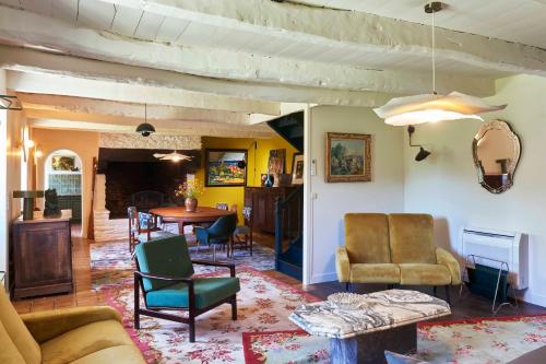 a living room with chairs and a table at La Longère de l'Amiral c'est au choix la Maison de l'Amiral jusqu'à 10 personnes ou le Carré de l'Amiral jusqu'à 4 personnes in Moëlan-sur-Mer