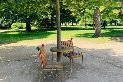 a table and two chairs sitting next to a tree at Královské apartmá kolonáda in Poděbrady