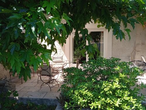 a patio with chairs and trees in front of a building at Mazet Des Artistes in Mouriès