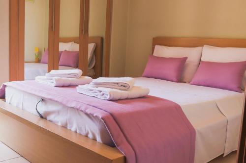 - une chambre avec un lit doté d'oreillers et de serviettes violets dans l'établissement Sunshine Apartments #02, à Thessalonique