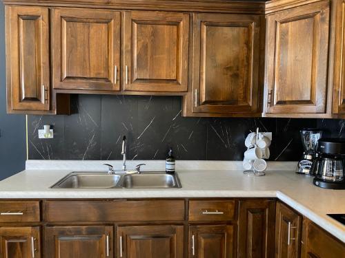 a kitchen counter with a sink and wooden cabinets at Ancla Suite 8 - 2 Bedroom Urban Hotel in Puerto Peñasco