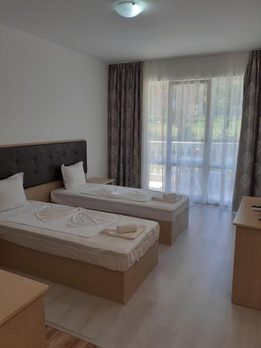 two beds in a room with a window at Perla Del Mar Aparthotel in Lozenets