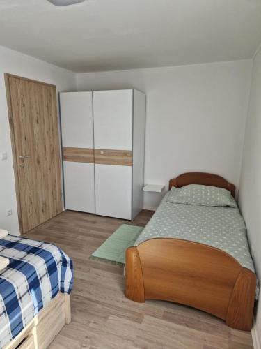 um pequeno quarto com uma cama e um armário em Apartma Tija em Tolmin