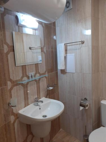 a bathroom with a sink and a toilet at Perla Del Mar Aparthotel in Lozenets