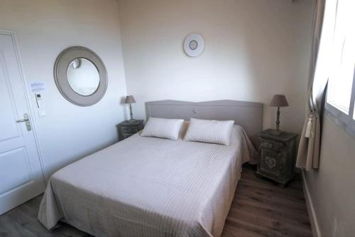 a white bedroom with a bed and a mirror at Villa Porto vecchio vue mer 5 étoiles piscine parking privé gratuit in Porto-Vecchio