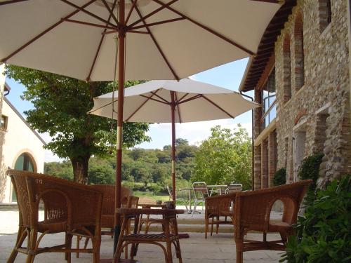 a table and chairs with umbrellas on a patio at Agriturismo Sambuco in Pastrengo