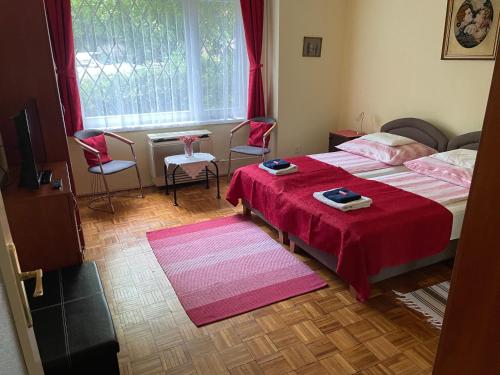 ブダペストにあるGERARDUS apartmanのベッドルーム1室(ベッド2台、テーブル、椅子付)