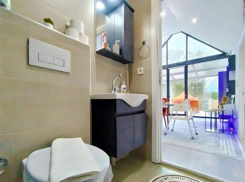 a bathroom with a sink and a toilet and a table at Villa Orange House Private Garden Terrace Hot tub Mountain views Konyaalti Antalya in Antalya