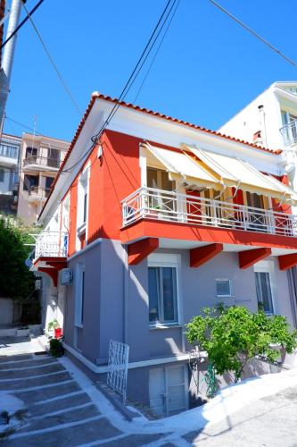 an orange and white building with a balcony at The Art House By The Sea in Plomarion