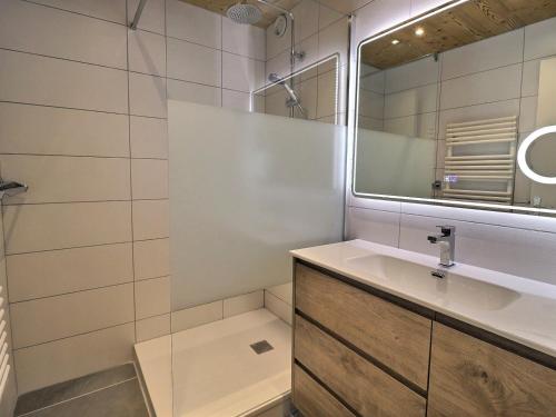 une salle de bain avec un lavabo et un miroir dans l'établissement Appartement 2 Pièces avec Coin Montagne, Calme et Idéal pour Famille, Proche Pistes aux Allues - FR-1-182-66, à Méribel