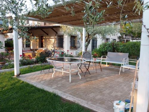 a patio with a table and chairs under a pergola at B&B Valverde in Dorgali