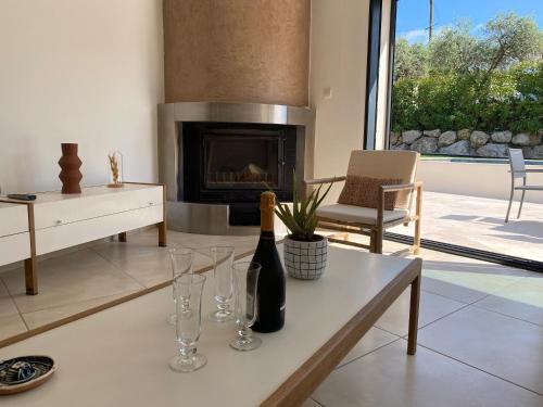 ein Wohnzimmer mit einer Flasche Wein und Gläsern auf dem Tisch in der Unterkunft Villa Côté Soleil in Auribeau-sur-Siagne