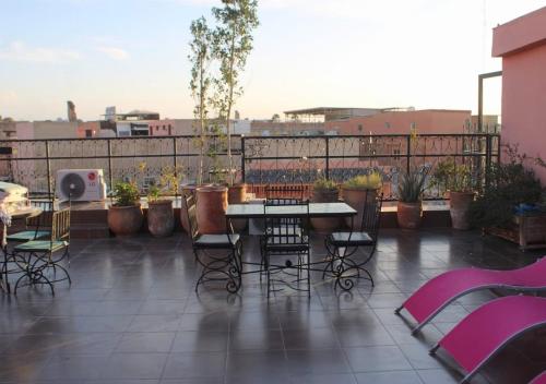 a patio with a table and chairs on a balcony at Résidence Miramare Marrakech in Marrakech
