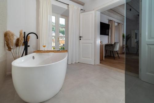 a white bath tub in a room with a television at Shee-Lu Suites in Dubrovnik