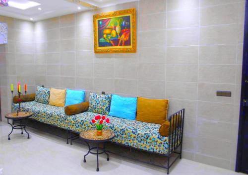 a couch with colorful pillows sitting in a room at Résidence Miramare Marrakech in Marrakech
