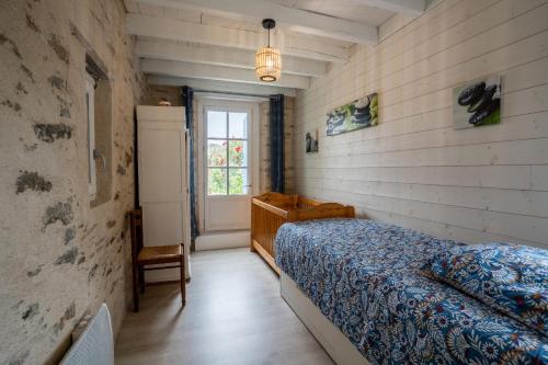 a bedroom with a bed and a window at maison tartifume in Pornic