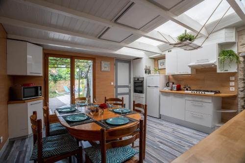 une cuisine et une salle à manger avec une table et des chaises dans l'établissement maison tartifume, à Pornic