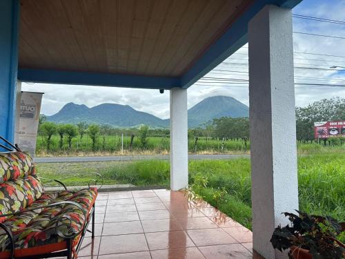 a porch with a couch and a view of mountains at La Casa de Detours Costa Rica in Fortuna