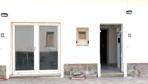 un edificio blanco con puertas de cristal y puerta en La Rosa Verde di Francavilla Marittima, en Francavilla Marittima