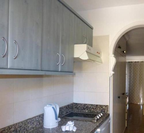 une cuisine avec des placards bleus et un comptoir dans l'établissement Estudio coqueto Torres del Sol, à Arona