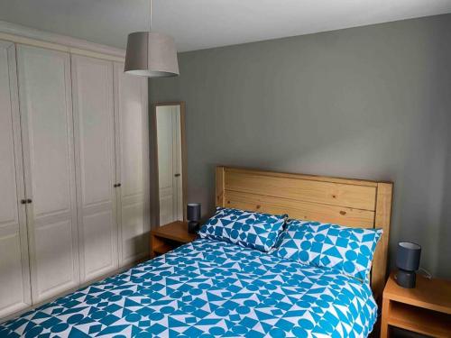 a bedroom with a bed with a blue and white comforter at Spacious Ground Floor 2 Bed by Lains Lettings in Aberdeen