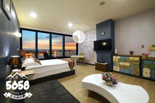 a bedroom with a large bed and a large window at 85 Cape Inn in Kaohsiung