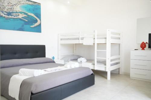 a bedroom with two beds and a white bunk bed at RESORT LEONARDO- Room, Pool & Restaurant in San Foca
