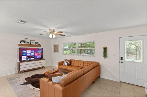 a living room with a couch and a flat screen tv at The Gator Getaway- Huge Backyard in Gainesville