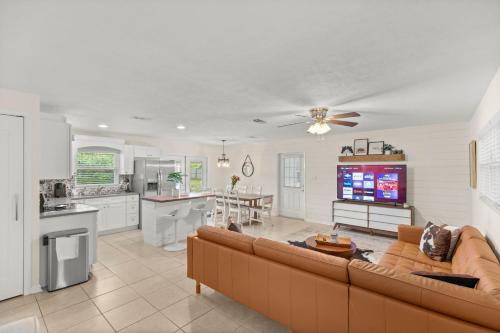 a living room with a couch and a kitchen at The Gator Getaway- Huge Backyard in Gainesville