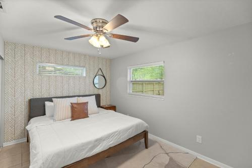 - une chambre avec un lit et un ventilateur de plafond dans l'établissement The Gator Getaway- Huge Backyard, à Gainesville