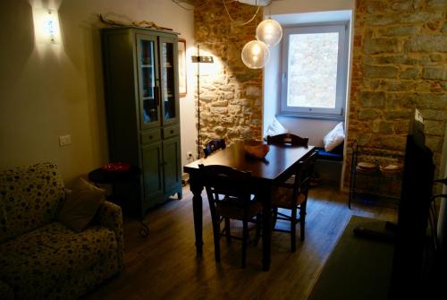 een eetkamer met een tafel en stoelen en een bank bij L'appartamento sotto la Torre in Campiglia Marittima