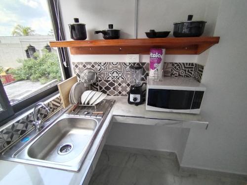 una piccola cucina con lavandino e finestra di Departamentos Santos a Valladolid