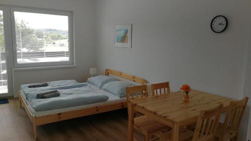 Milešov的住宿－Apartmány Orlík - Loužek，一间卧室配有一张床、一张桌子和闹钟