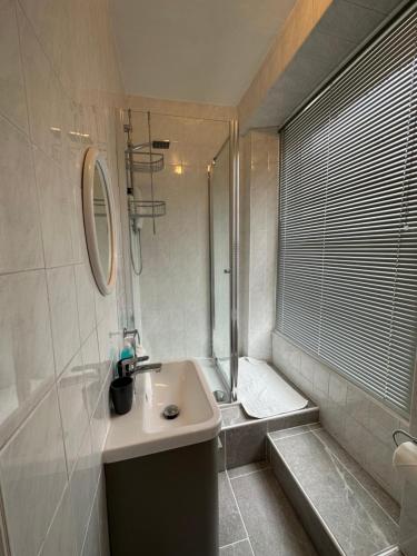 a white bathroom with a sink and a shower at Manor Lodge Guesthouse in Keynsham