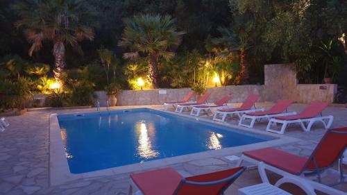 a swimming pool with lounge chairs and a swimming pool at Residence Helios in Cargèse