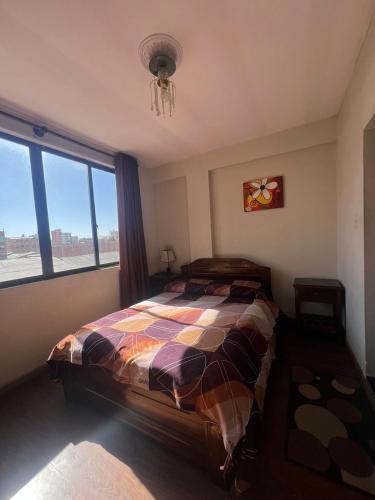 ein Schlafzimmer mit einem Bett und einem großen Fenster in der Unterkunft Hostal Graciela in Oruro