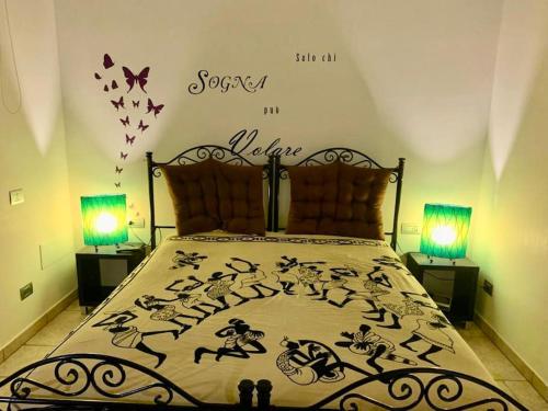 a bedroom with a bed with two lamps and butterflies on the wall at Seconda stella a destra in Taranto