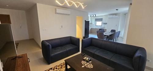 uma sala de estar com um sofá e uma mesa em Marina Marassi, North Coast em Sīdī ‘Abd ar Raḩmān