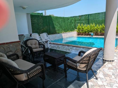 patio con sedie e piscina di Begonville Villas Ladies Beach a Kusadası