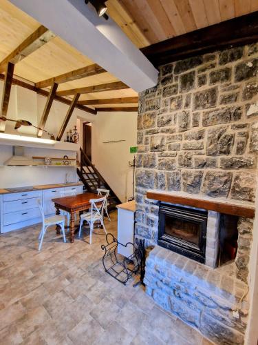 a living room with a stone fireplace and a table at Pixie House - Mrežnica, private pier, hot tub in Gornji Zvečaj