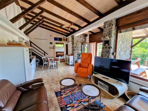 a living room with a large tv and a couch at Pixie House - Mrežnica, private pier, hot tub in Gornji Zvečaj