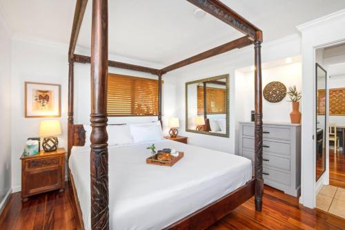 a bedroom with a four poster bed and a mirror at KBM Resorts International Colony Club ICC-11 2Bdm in Kaanapali