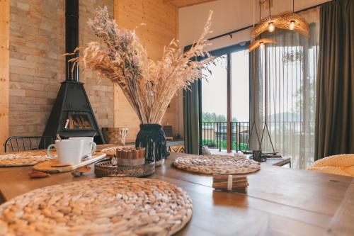 a dining room with a table and a fireplace at Dakota forest retreat in Tsigov Chark