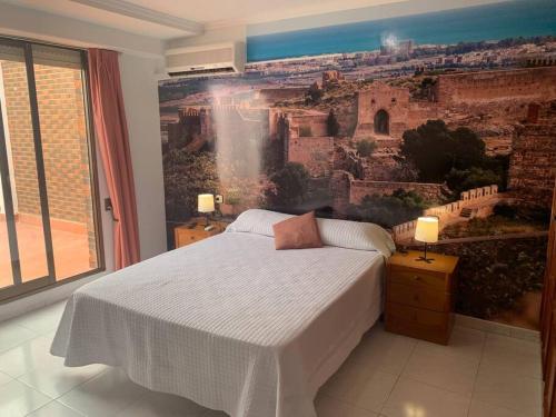 ein Schlafzimmer mit einem großen Gemälde an der Wand in der Unterkunft Apartamento Castillo - Alquiler de temporada in Puerto de Sagunto