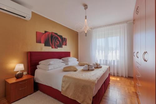 ein Schlafzimmer mit einem großen Bett mit weißen Kissen in der Unterkunft Apartments Rusula Zadar in Zadar