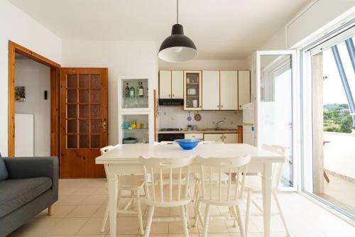 uma cozinha e sala de jantar com uma mesa branca e cadeiras em VistaMare Paradiso em Torre Vado